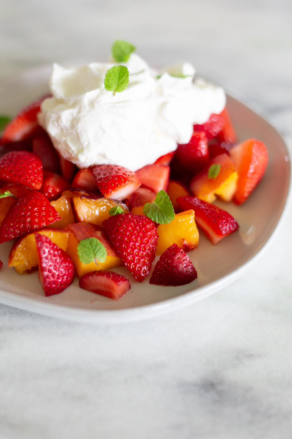 Peaches and Strawberries with Almond Whipped Cream on a plate