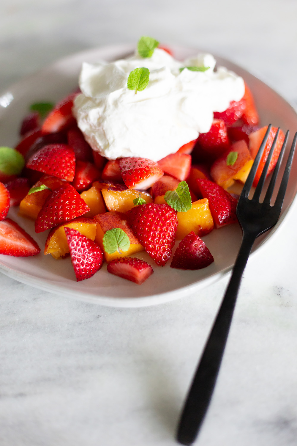 Peaches and Strawberries with Almond Whipped Cream with a fork