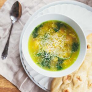 Chicken and quinoa soup in a white bowl.