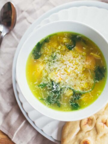 Chicken and quinoa soup in a white bowl.