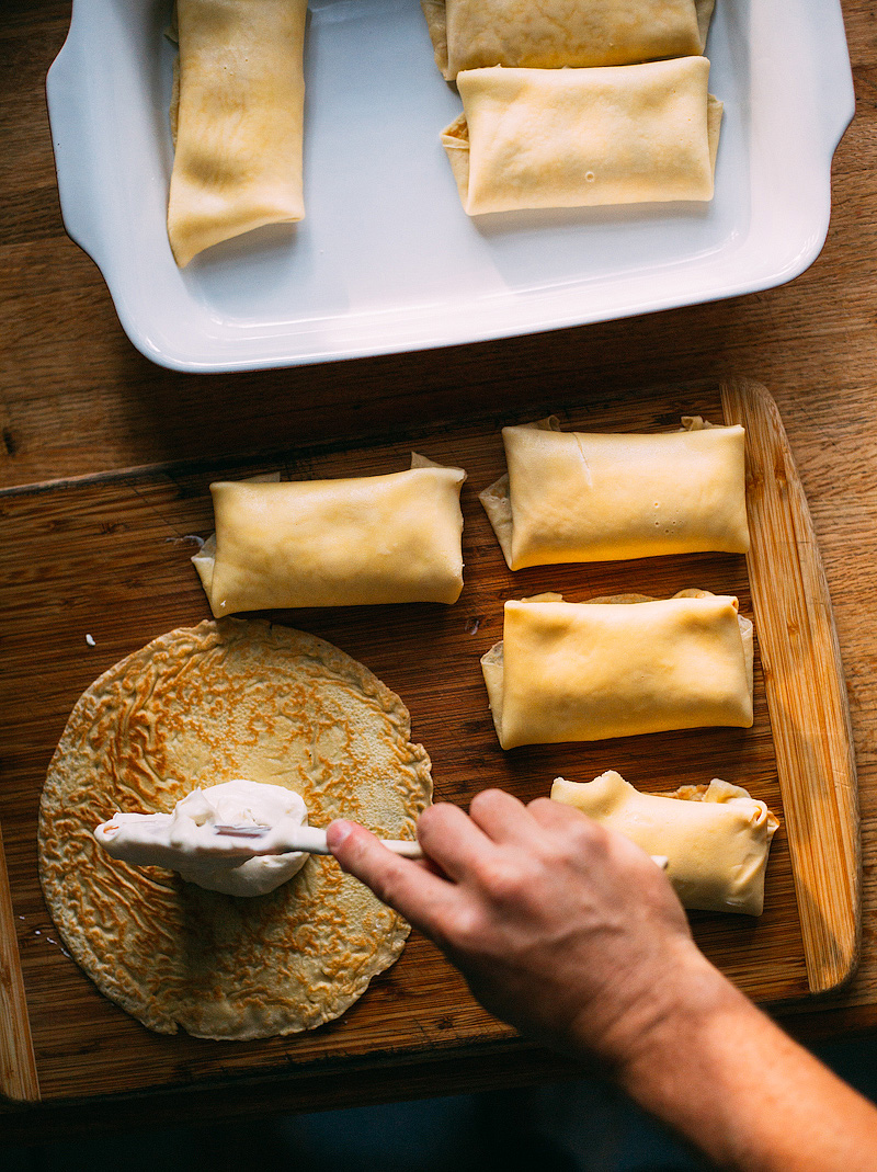 adding the cheese mixture to blintzes