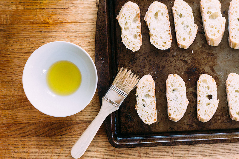 brushing olive oil on crostini