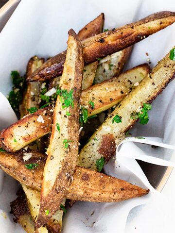 Oven baked fries topped with minced garlic and fresh parsley.