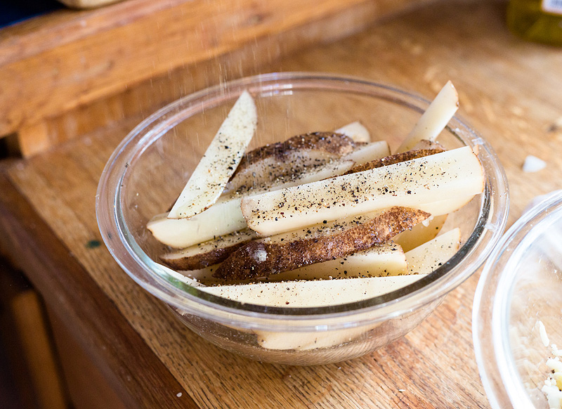 seasoning a potato with pepper