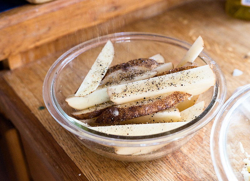 seasoning a potato with pepper