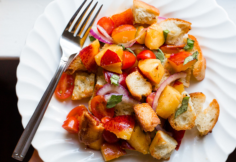 peach panzanella salad with tomatoes up close on a plate