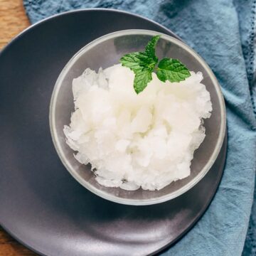 Lemon granita in a small bow with mint leaves.