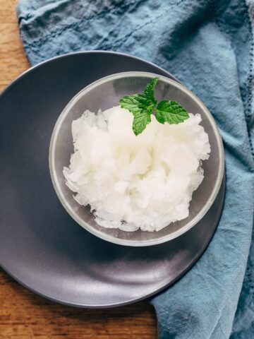 Lemon granita in a small bow with mint leaves.
