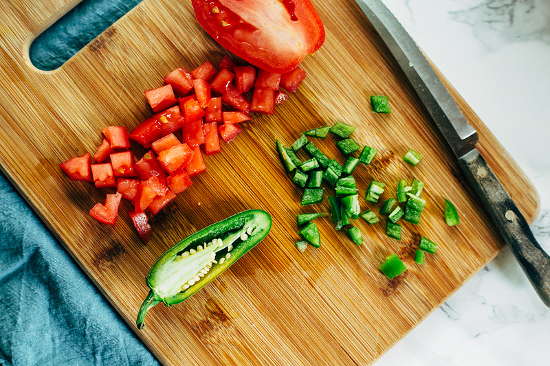 chopping jalapenos and tomatoes