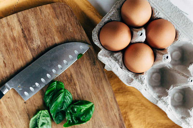 basil and four eggs in a carton