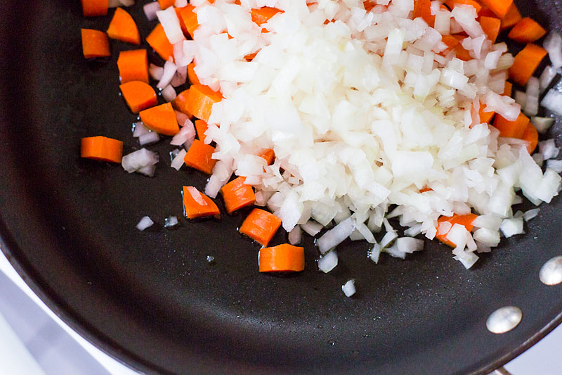 carrots and onions cooking in a skillet