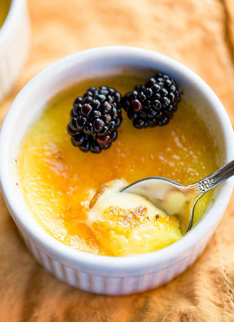 creme brulee with two blackberries on top