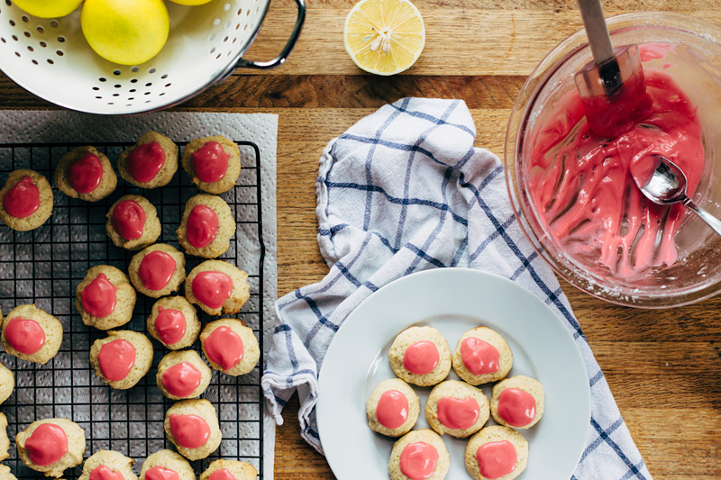 buttermilk cookies being topped with a raspberry glaze