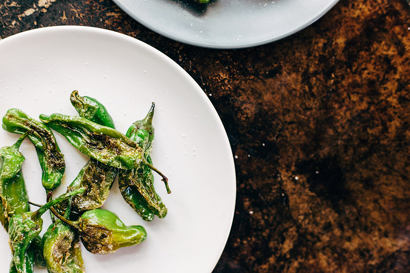 blistered shishito peppers on a plate