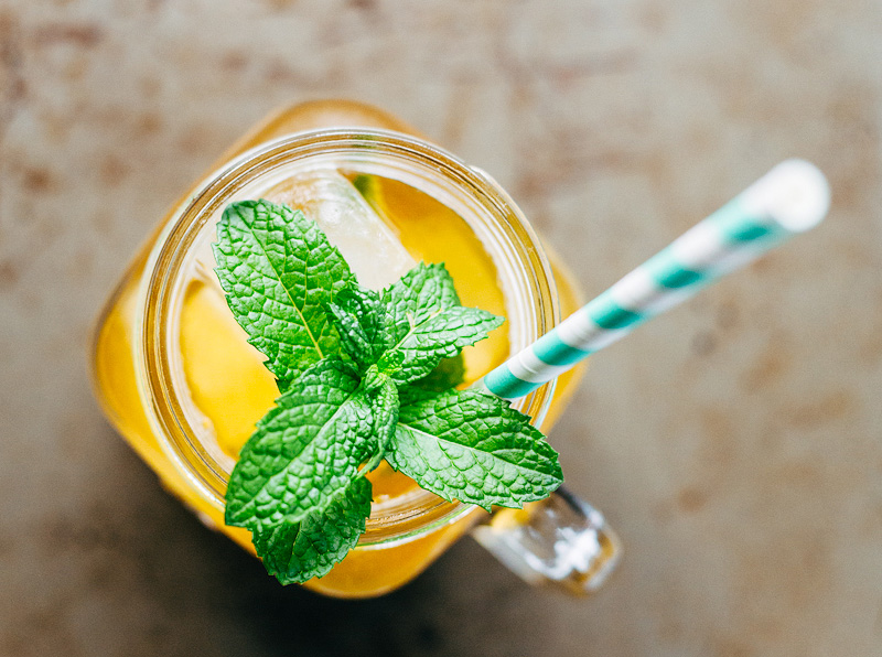 Peach iced tea with a straw and fresh mint