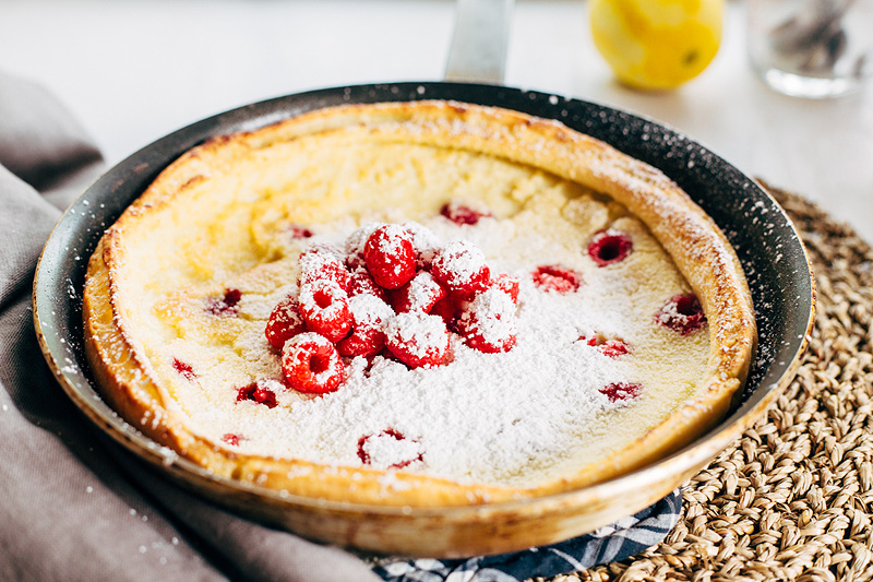 Raspberry Dutch Baby Pancake with fresh raspberries and powdered sugar