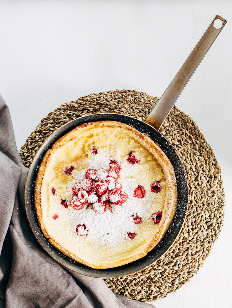 Raspberry Dutch Baby Pancake with fresh raspberries and powdered sugar