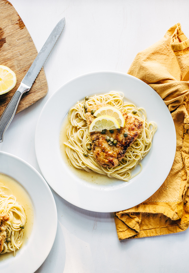 Chicken Piccata on a plate with lemon slices and capers