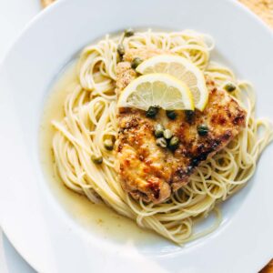 Chicken piccata with capers and lemon slices.