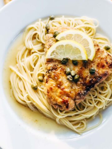 Chicken piccata with capers and lemon slices.