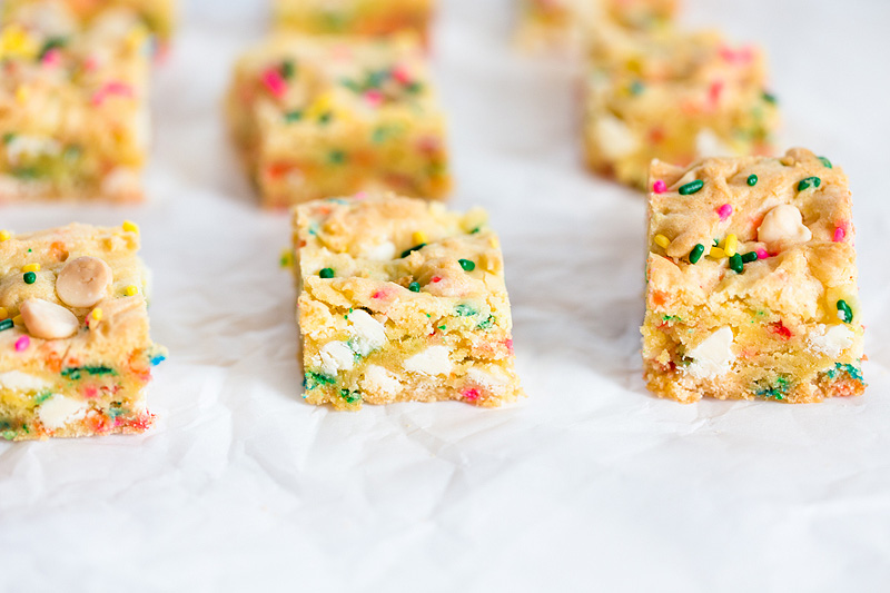 Gooey Confetti Cake Bars on parchment paper