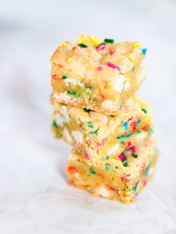 Cookie bars with sprinkles stacked on each other.