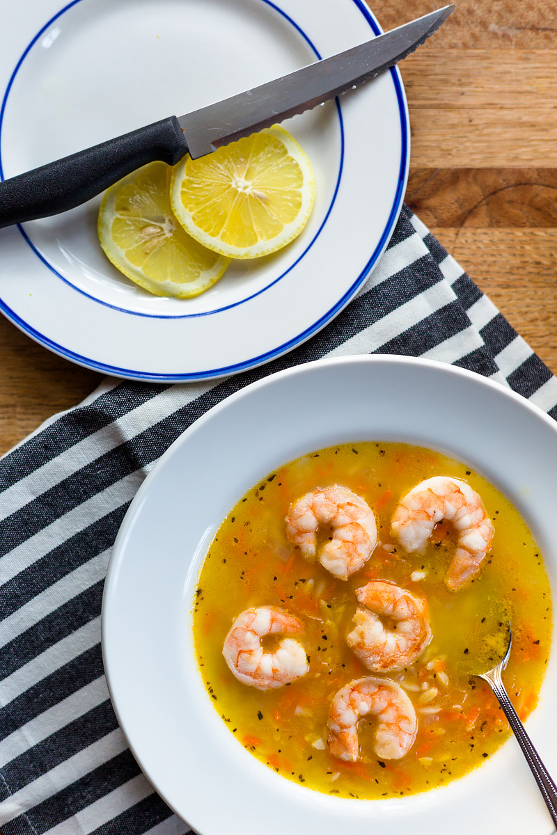 soup in a bowl with lemon slices on the side