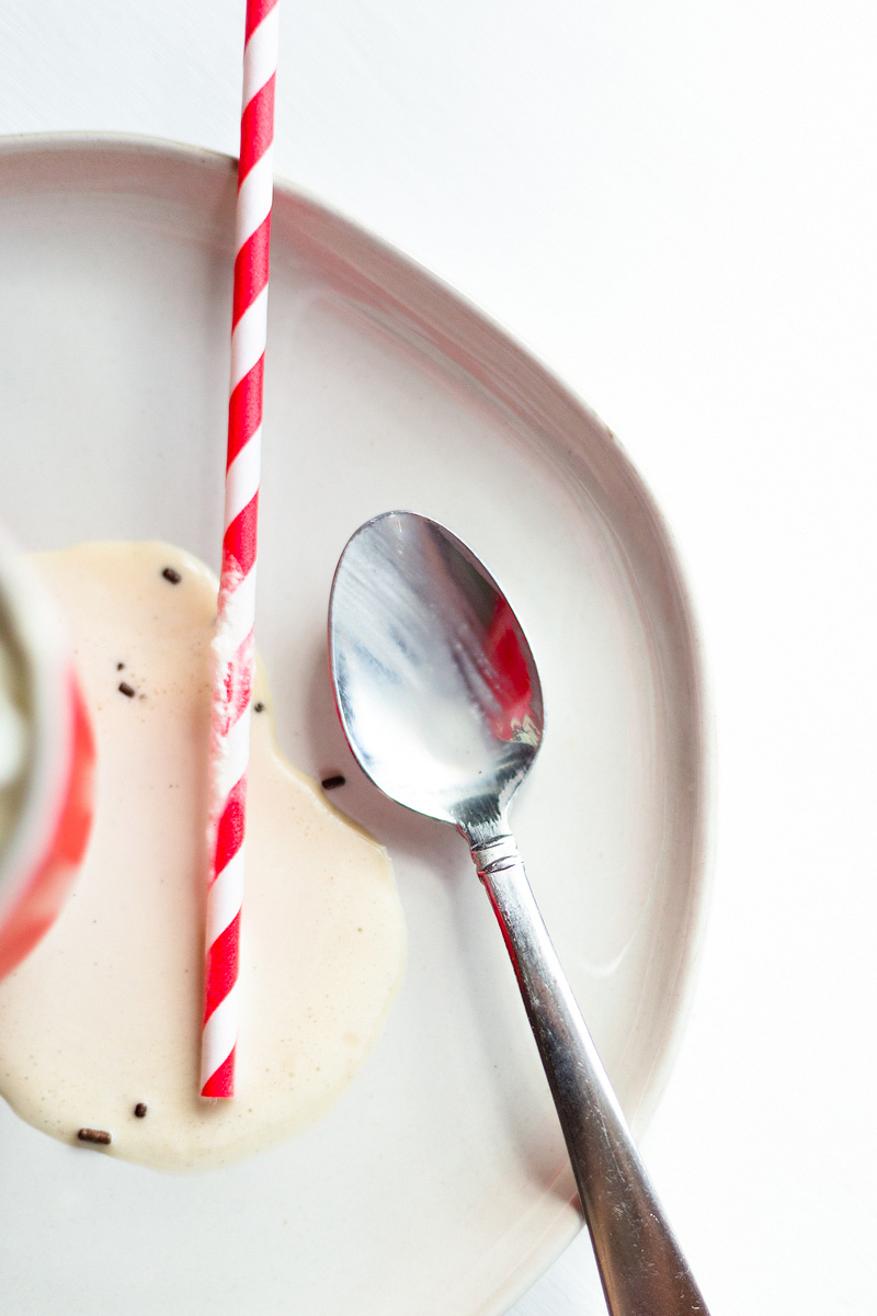 straw on a plate with melted ice cream and a spoon