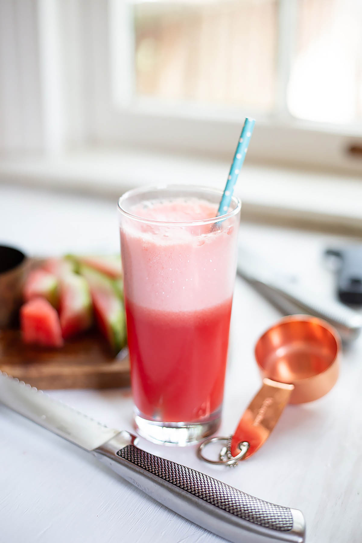 watermelon cucumber cooler in a glass with a blue straw