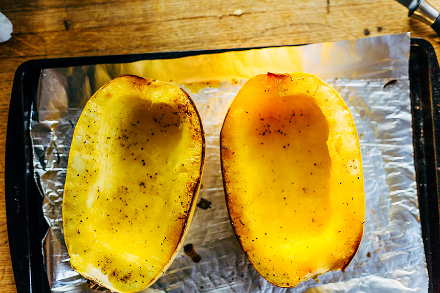 cooked spaghetti squash on a baking sheet