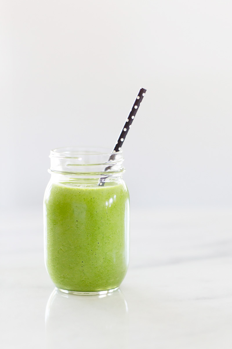 Tropical Green Smoothie with a black straw.