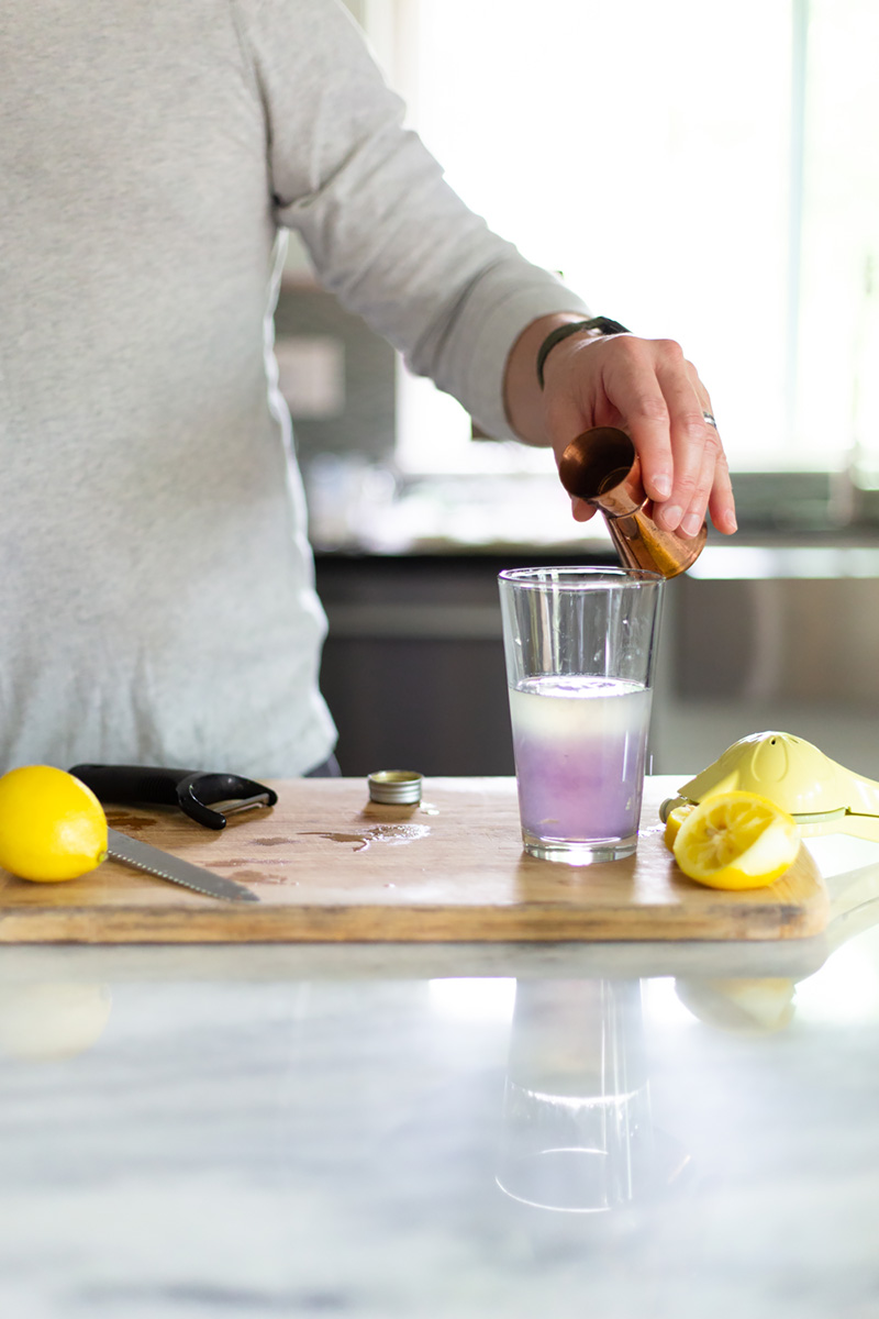 adding creme de violette to a glass.