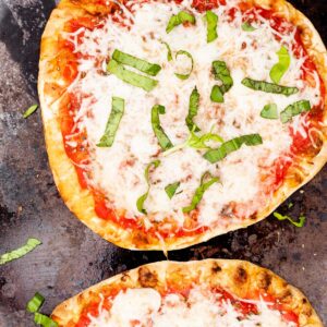 Naan pizzas on a cookie sheet