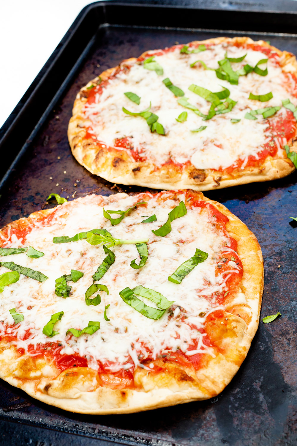 naan pizzas with basil on top