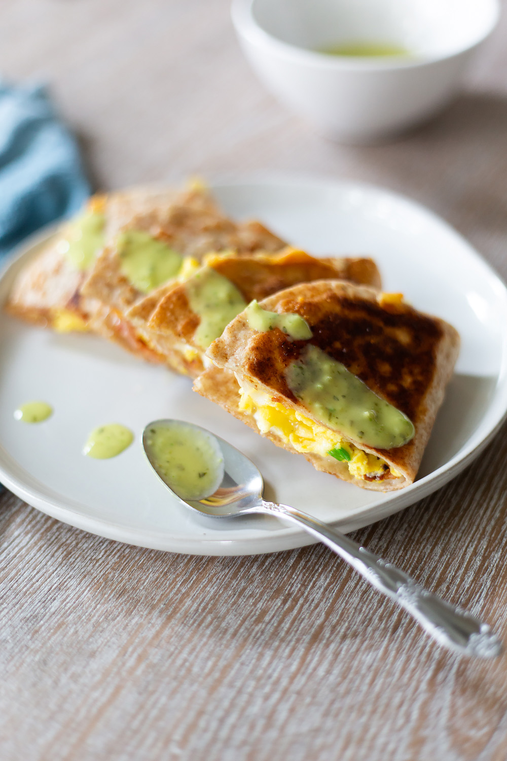 quesadilla with green salsa and a spoon.