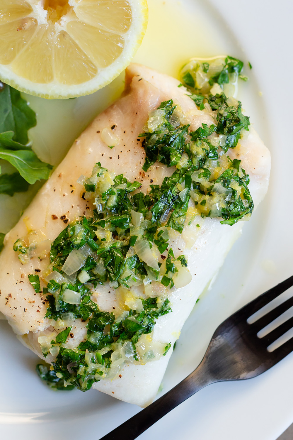 cod with a parsley sauce up close.