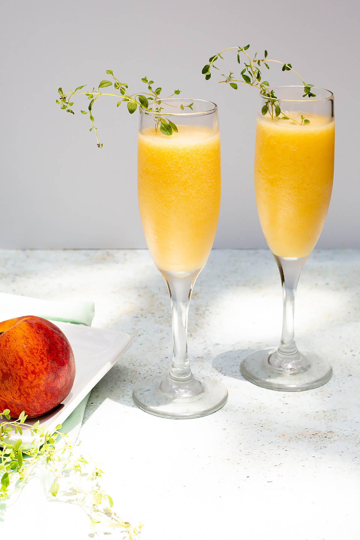 peach bellini mocktails with a peach on the side.