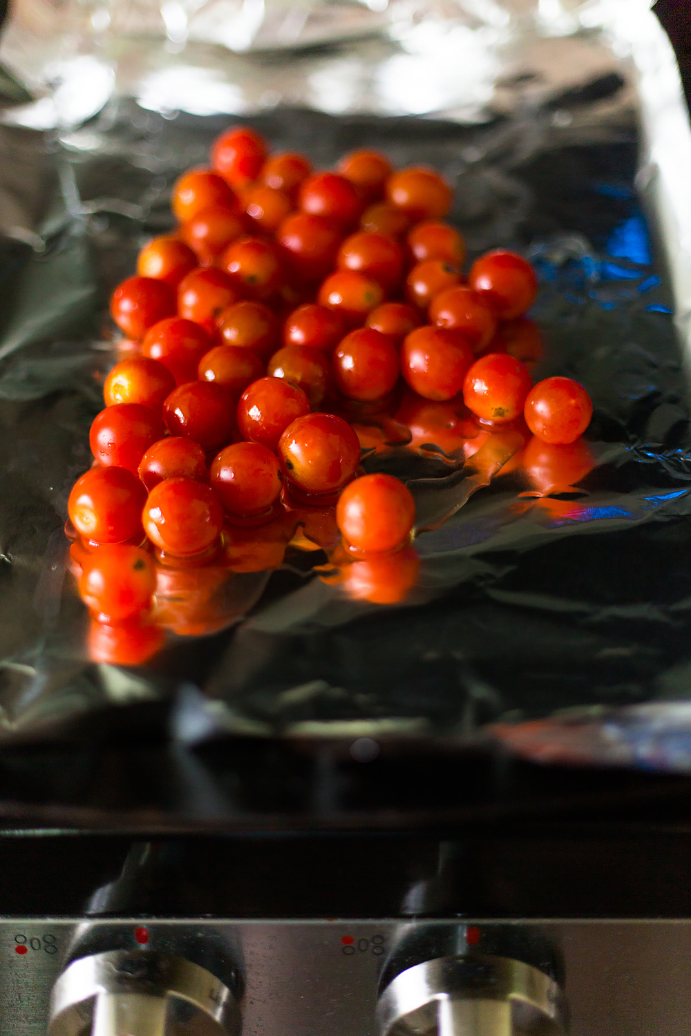 cherry tomatoes on foil on a baking sheet.