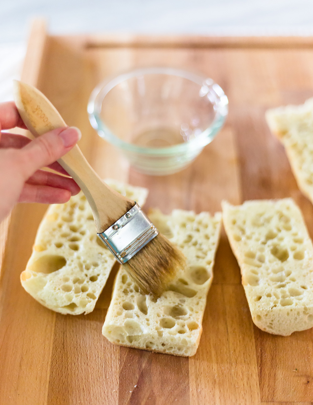 spreading oil on bread with a pastry brush.