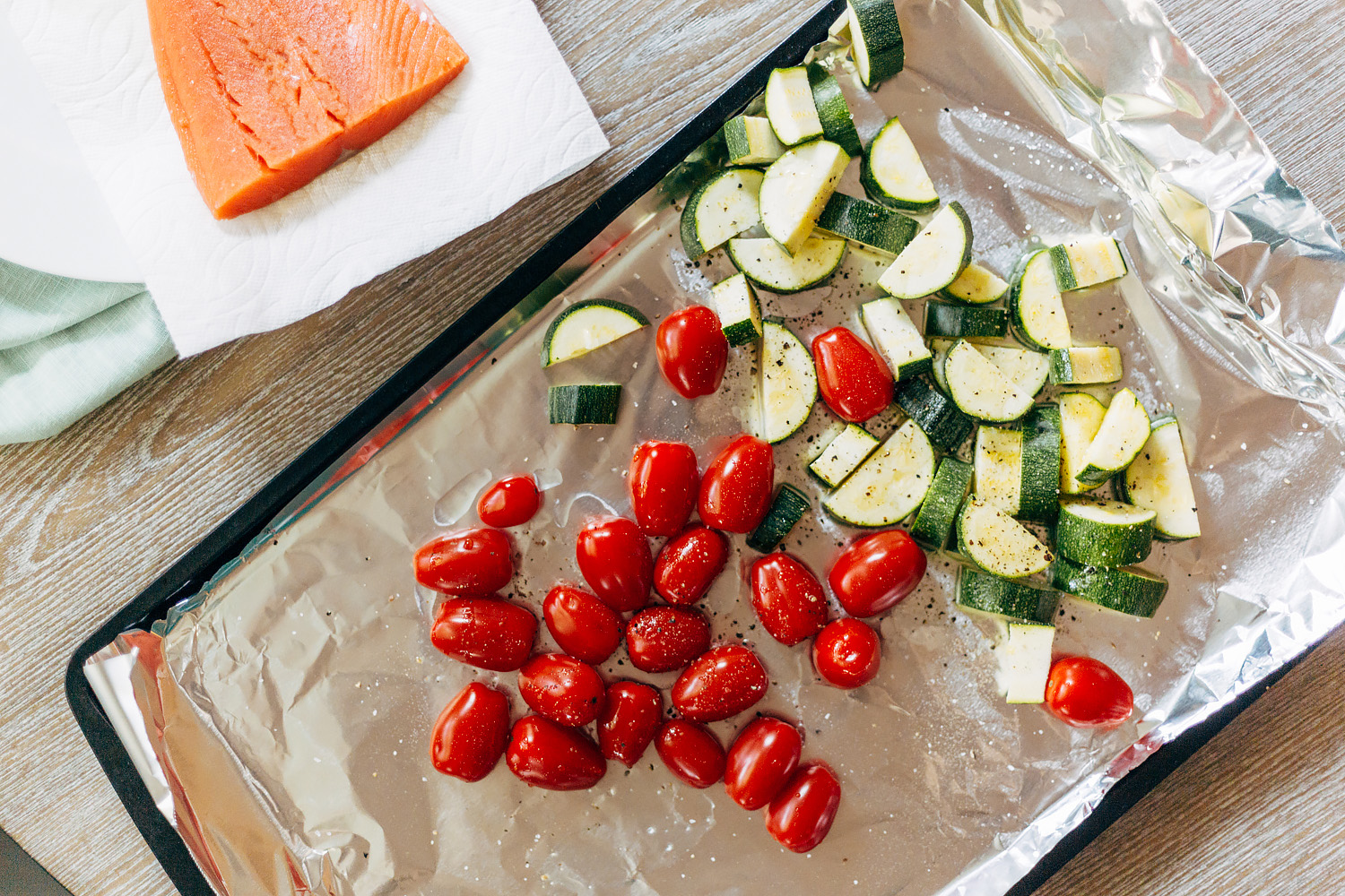 zucchini and tomatoes on a baking sheet