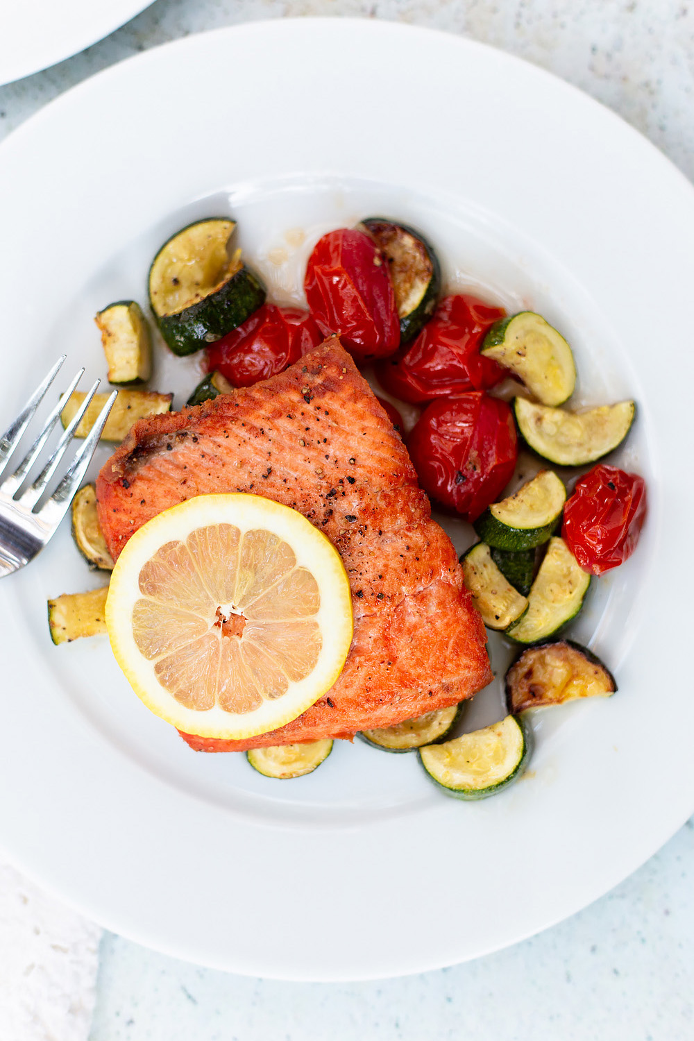 salmon with roasted veggies and a lemon slice