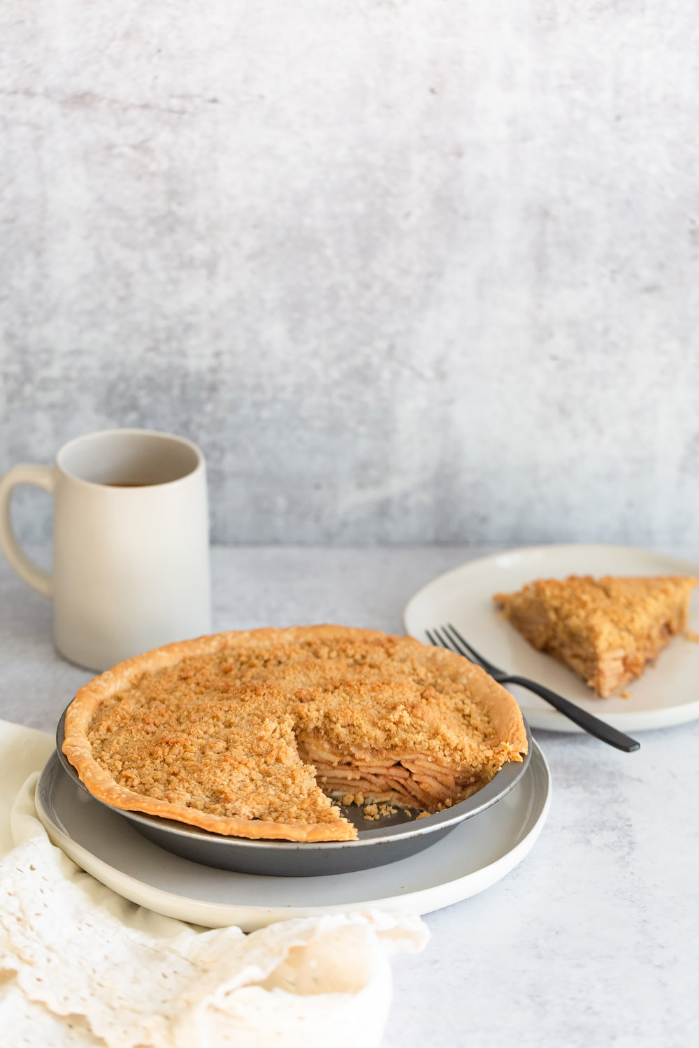 apple pie in a pie tin with a slice cut out