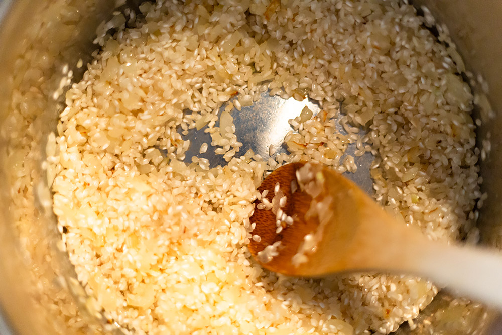 stirring arborio rice for parmesan risotto