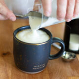 adding foamed milk to a cappuccino