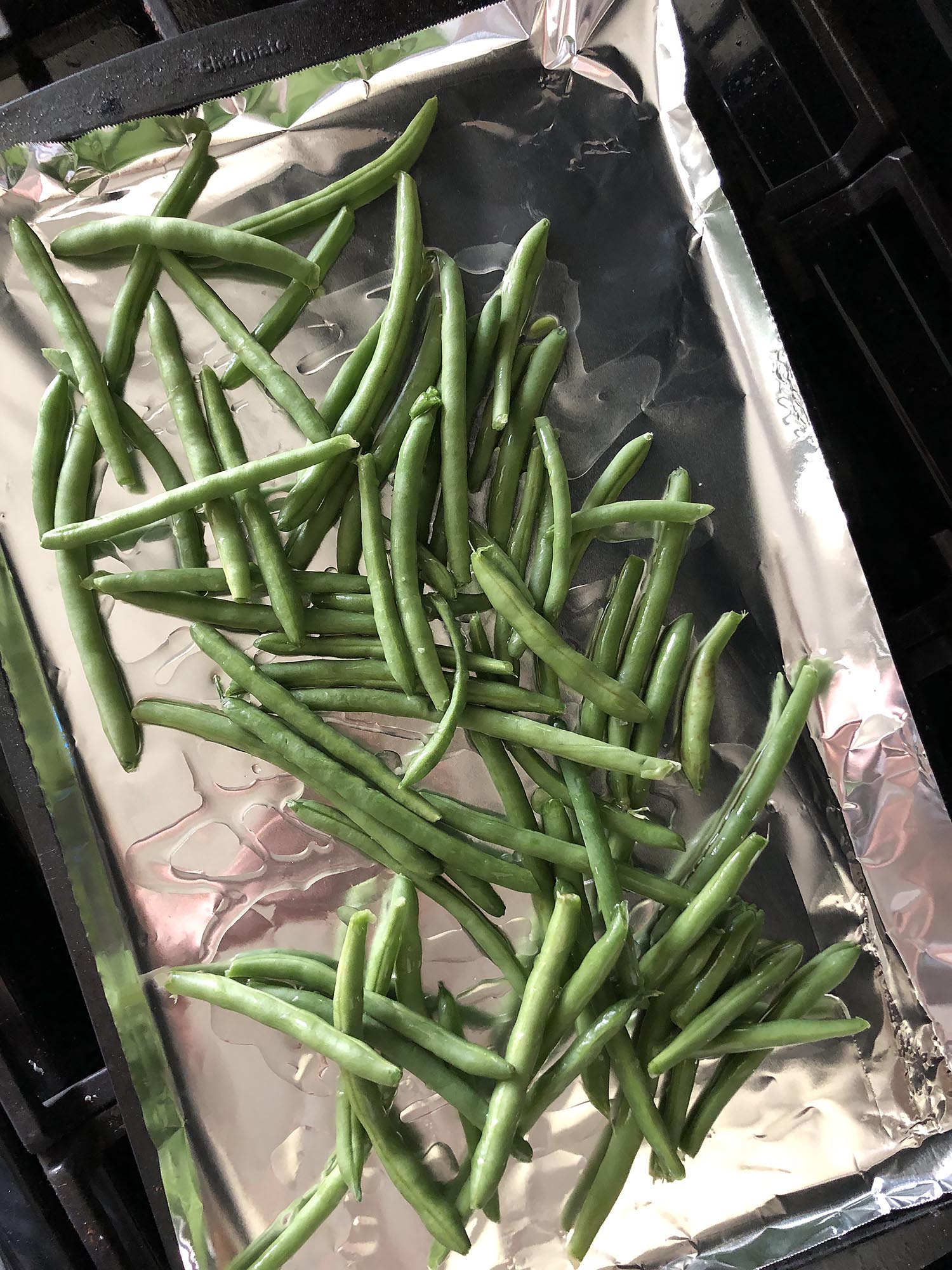 green beans on a foil lined baking sheet