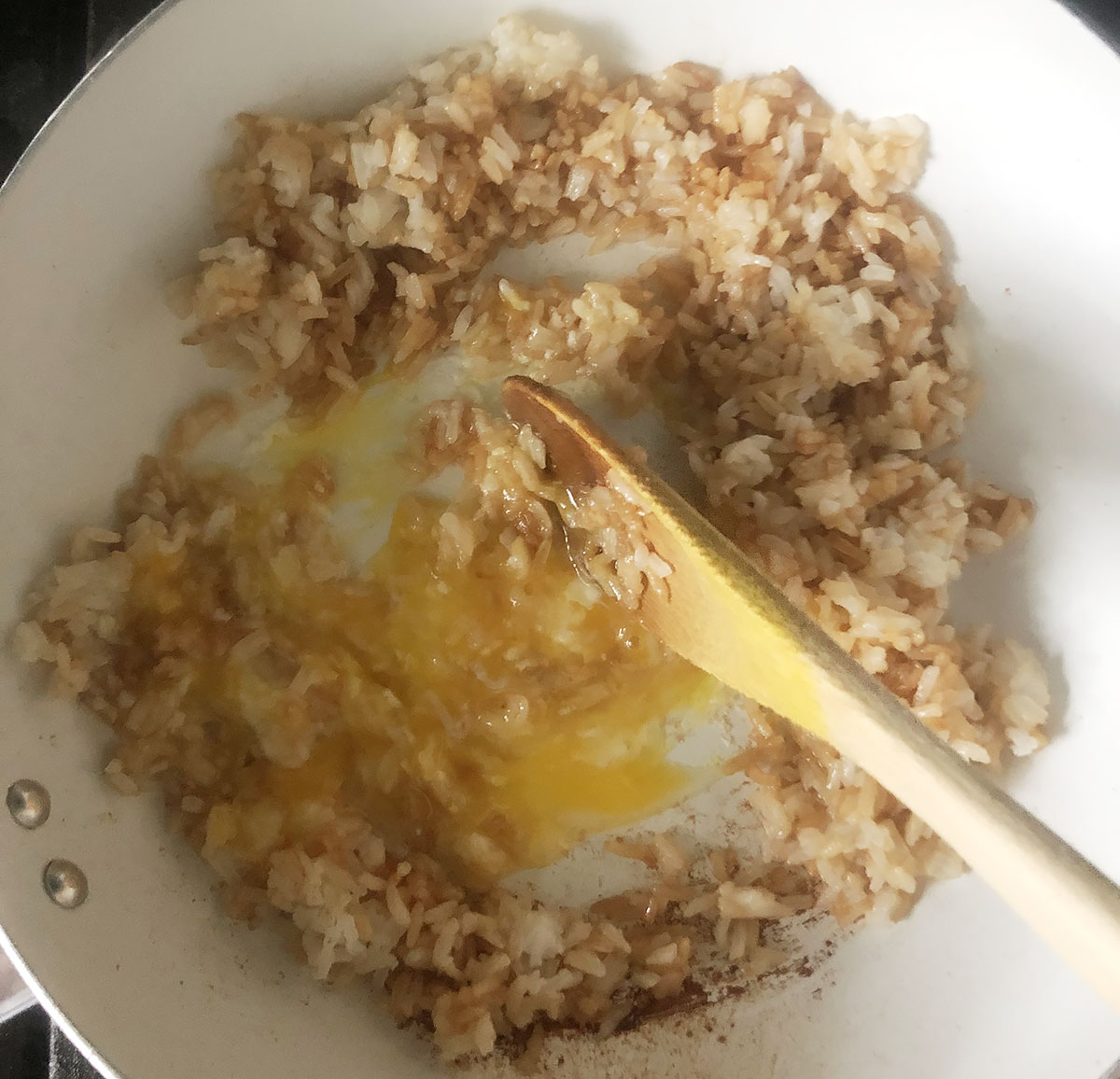 stirring an egg into fried rice