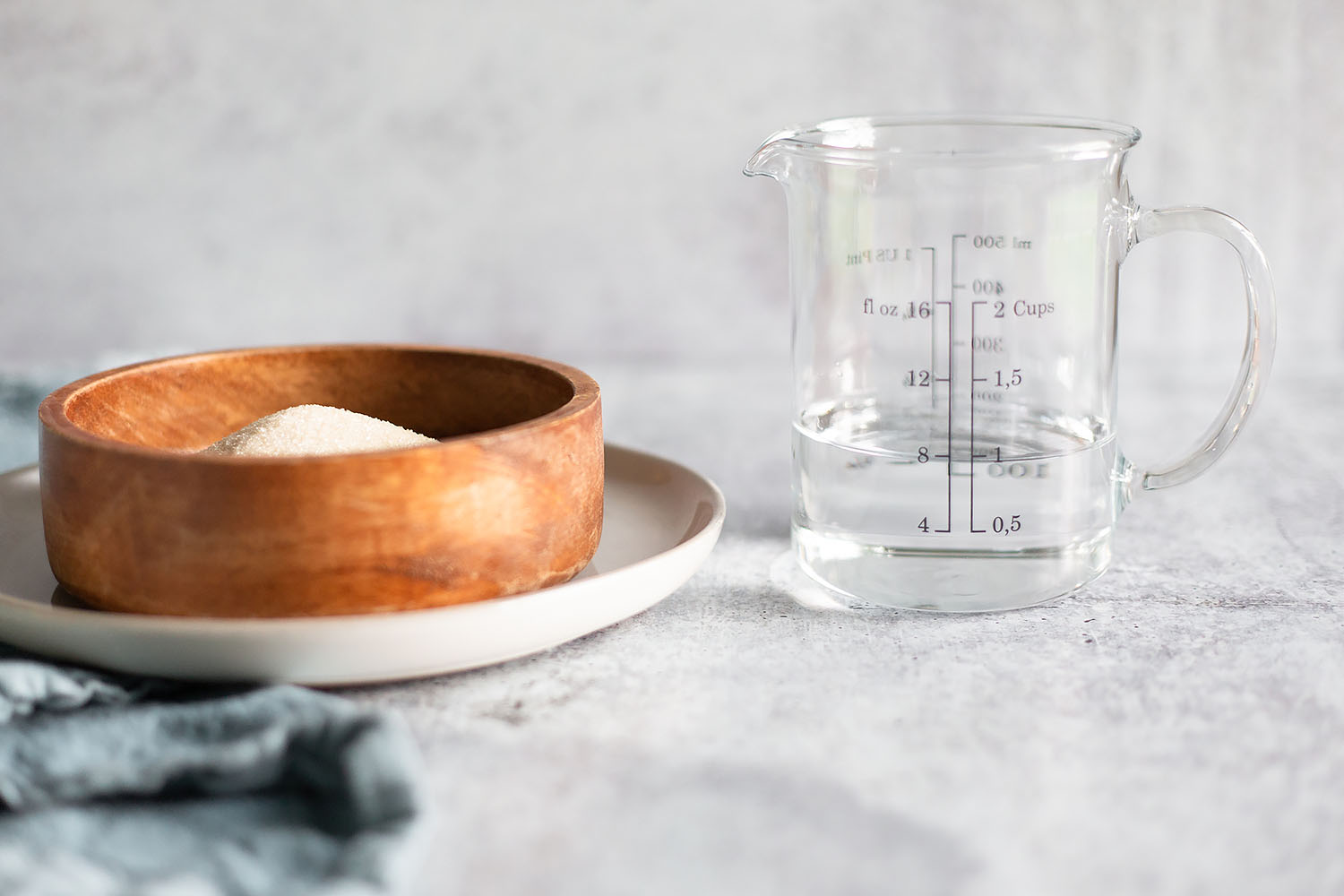 sugar in a bowl and water in a measuring cup
