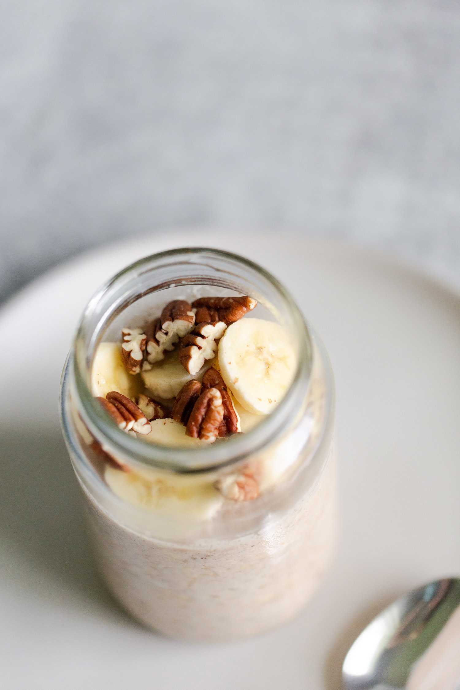 banana bread overnight oats topped with pecans and sliced bananas