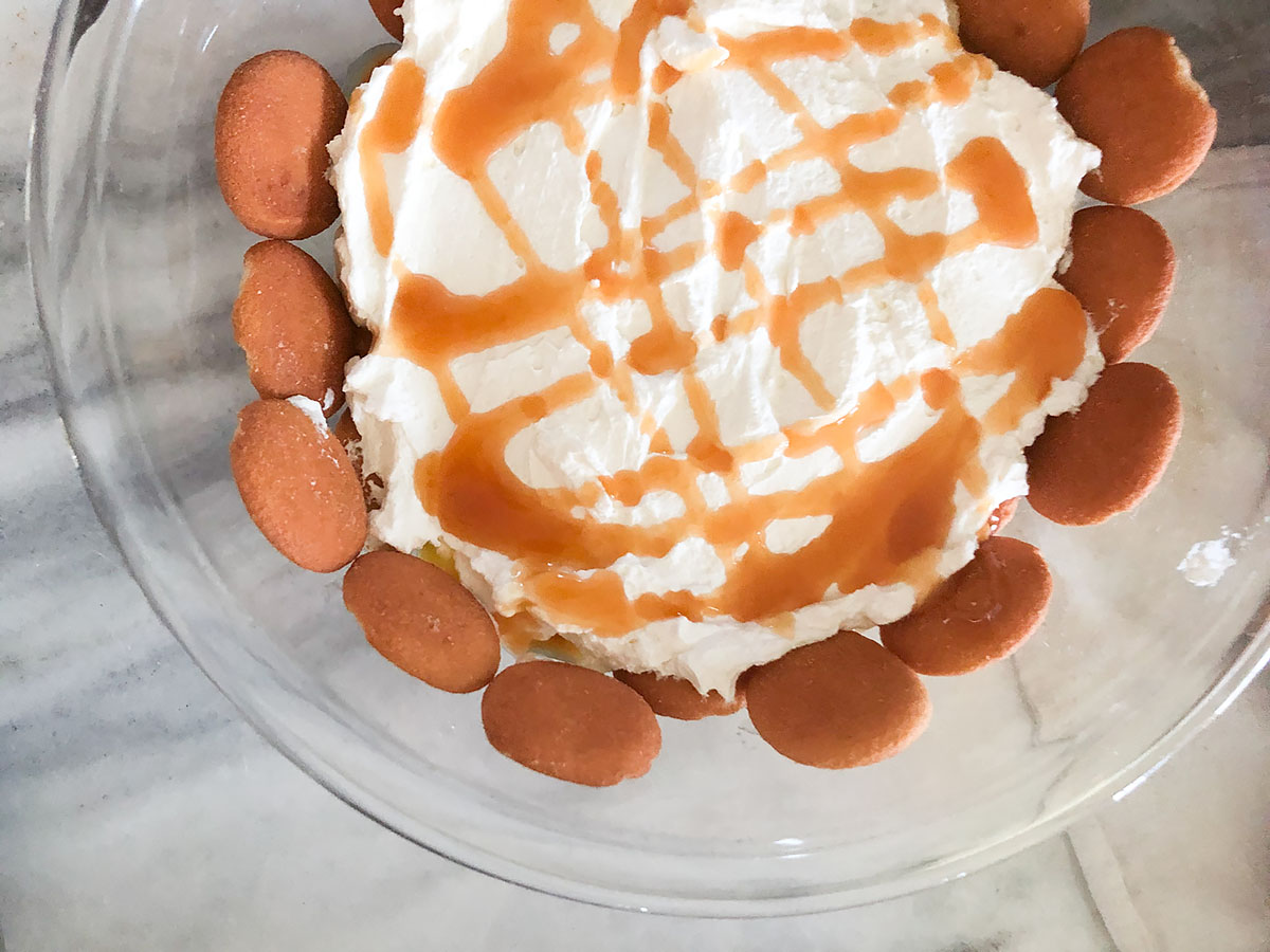 adding caramel drizzle to banana pudding