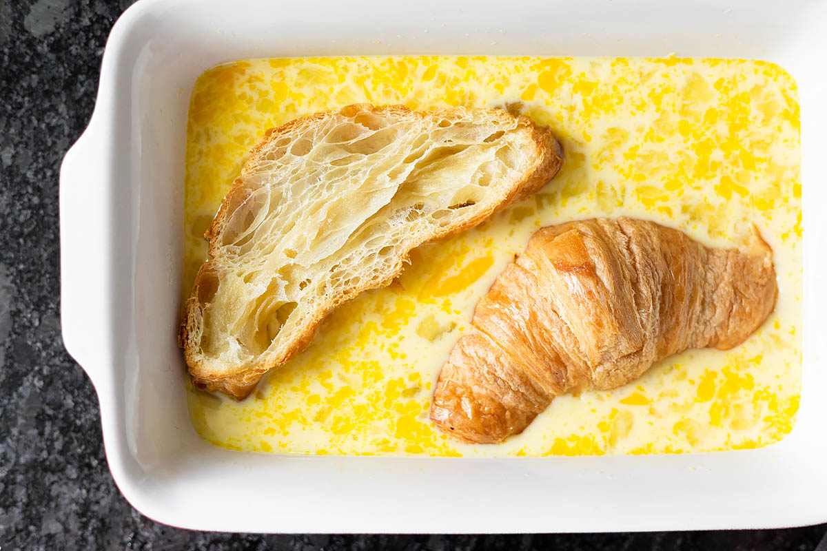 croissants being dipped in eggs and milk for french toast